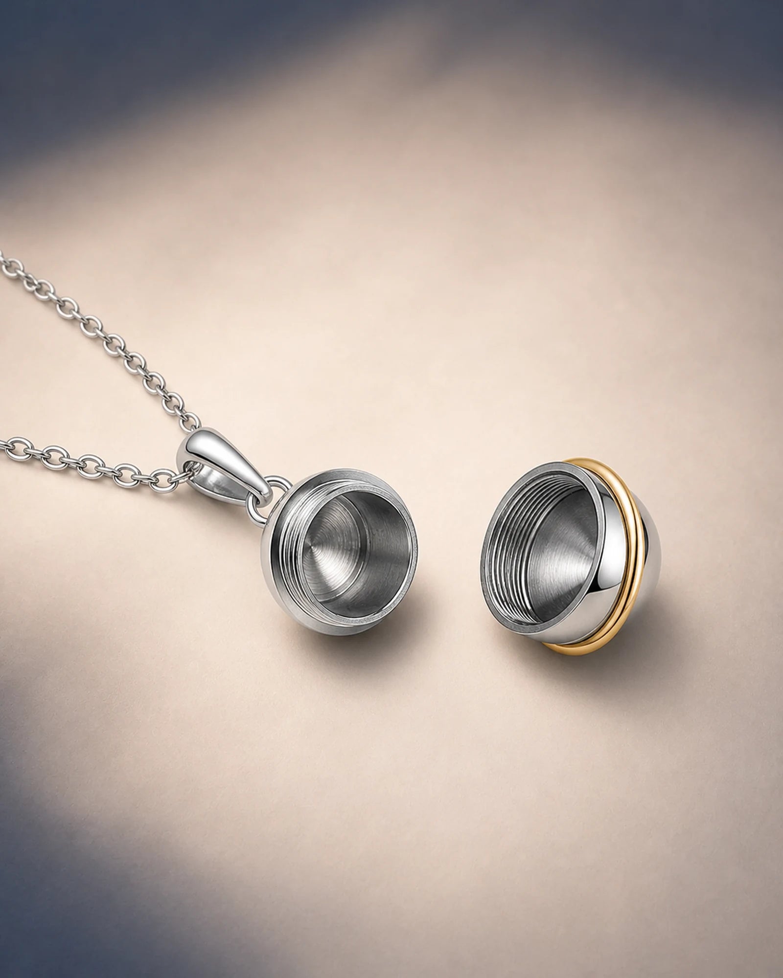 Orbit keepsake pendant opened into two threaded hemispherical sections