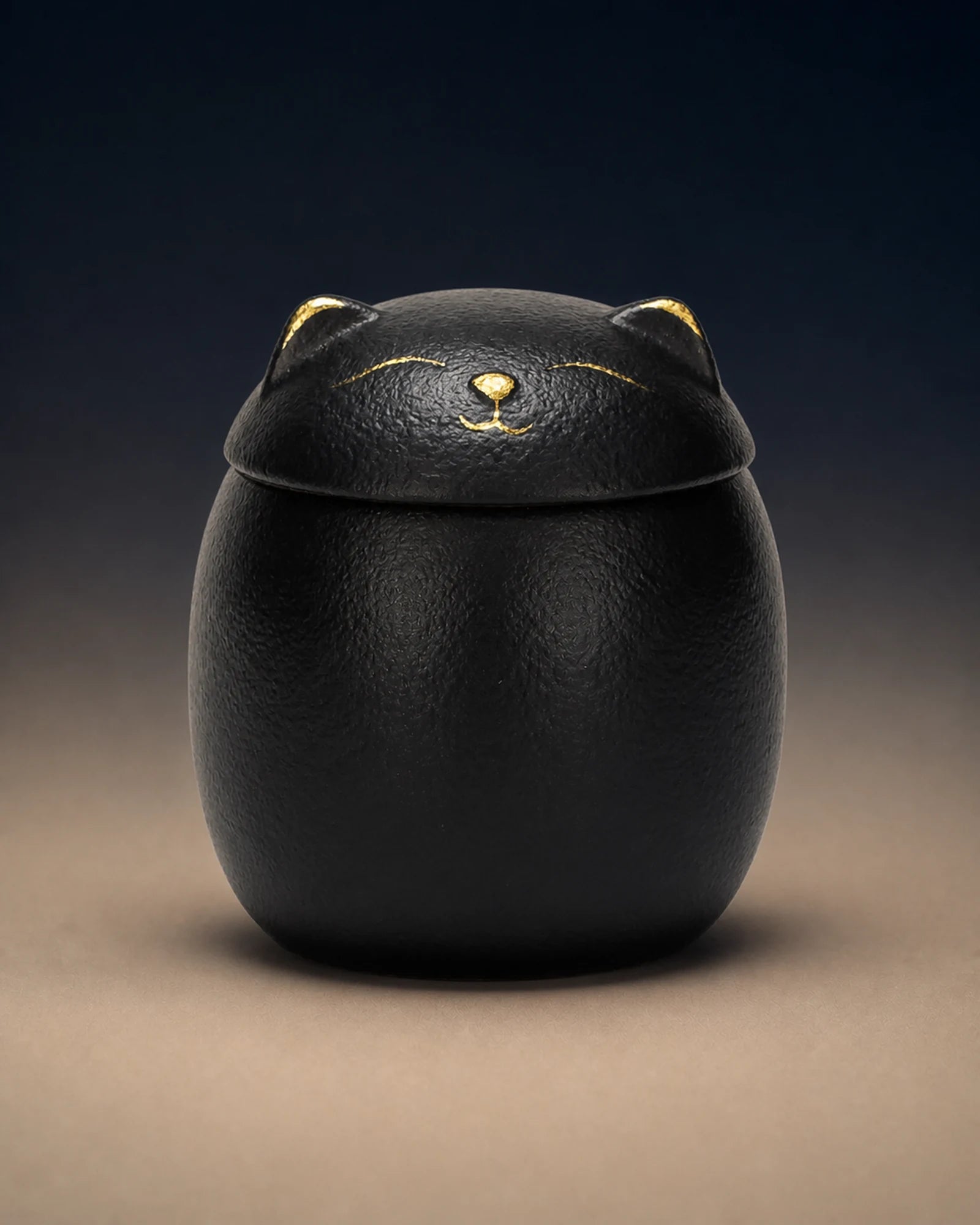Black cat-shaped memorial urn with restrained gold facial details