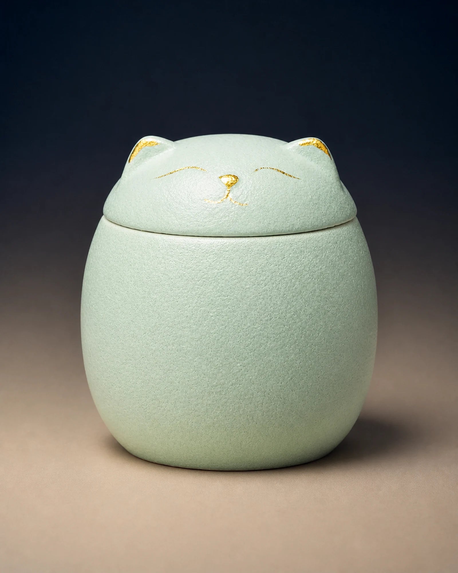 Green cat-shaped memorial urn with restrained gold facial details