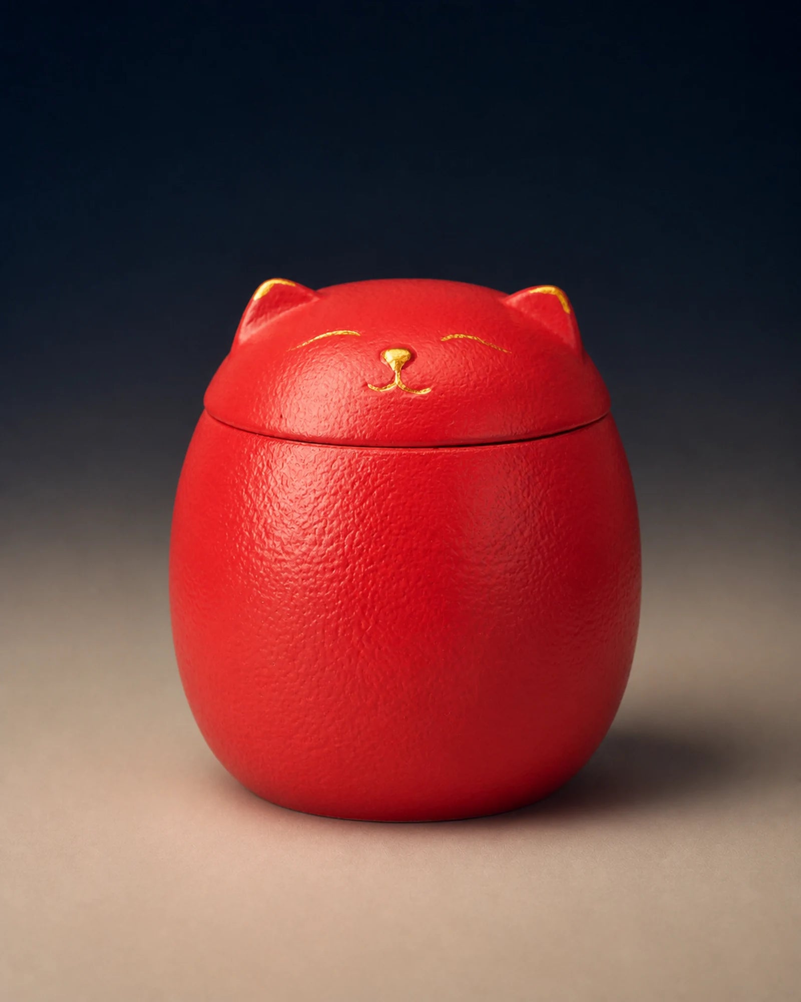 Red cat-shaped memorial urn with restrained gold facial details