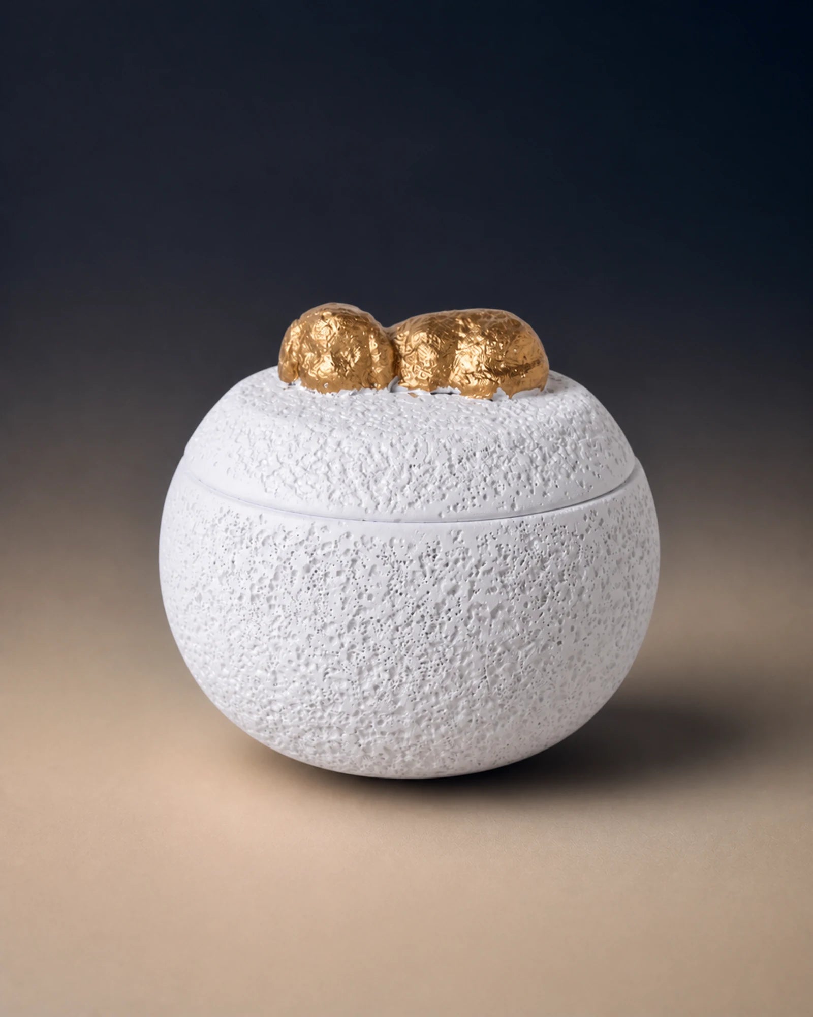 White cement-textured memorial urn topped with a small gold sleeping dog